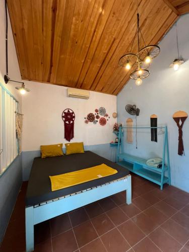 a bed in a room with a wooden ceiling at Vietnam Phuot Real Home in Kon Tum