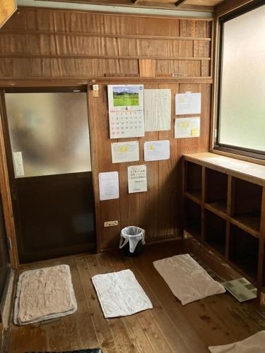 a room with a door and a window and mats at Hostel Knot in Izu