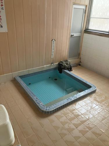 a swimming pool in the middle of a bathroom at Hostel Knot in Izu