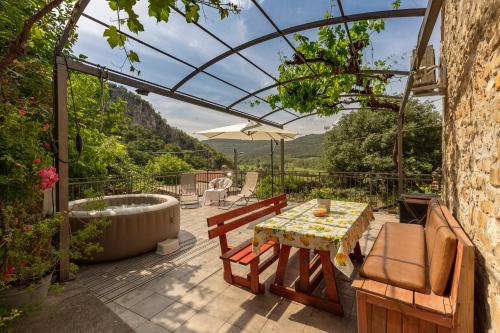 a patio with a tub and a table and chairs at Under the rock house in Osp with jacuzzi in Osp