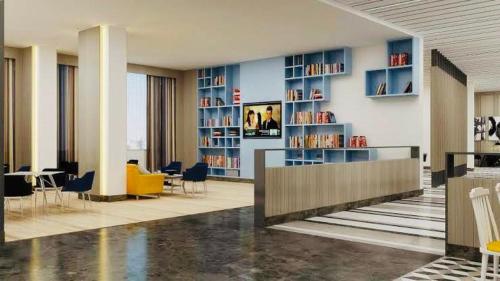 a lobby with a library with chairs and tables at Country Inn & Suites By Migrolino in Lucknow