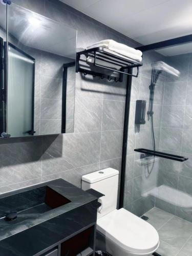 ein Badezimmer mit Toilette, Waschbecken und Dusche in der Unterkunft 杏花小筑豪华大床房 in Hongkong