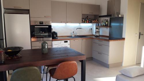 une cuisine avec une table en bois et quelques chaises dans l'établissement Le Gecko Sea View, à Sainte-Maxime