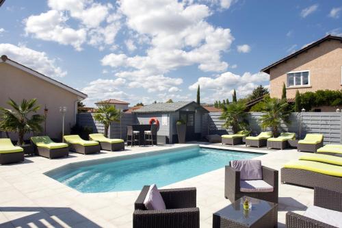 une piscine avec des chaises longues et une terrasse dans l'établissement Contact Hôtels Les Pierres Dorées, à Ambérieux d'Azergues