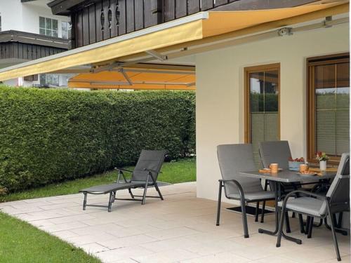 a patio with a table and chairs under awning at Holiday apartment Bergzeit, Allgäublick Steibis in Steibis