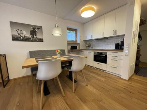 a kitchen with a table and chairs in a room at Holiday apartment Bergzeit, Allgäublick Steibis in Steibis