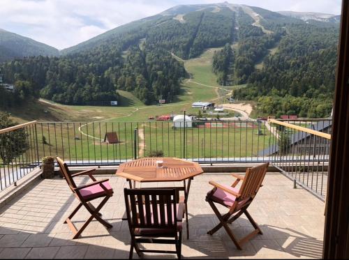 a table and chairs on a balcony with a view of a mountain at Studio&apartments Snow in Bjelašnica