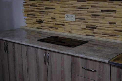 a kitchen with a counter top with a brick wall at Gam guest house 1 in Meghri