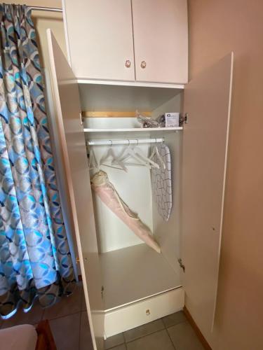 a closet with white cabinets and a curtain at MARATHES STUDIOS in Agios Nikitas