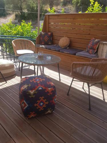 a patio with two tables and chairs and a bench at MARATHES STUDIOS in Agios Nikitas