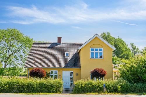 a yellow house with a black roof at Beautiful Yellow Country Villa By The Water in Millinge