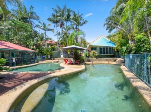 a large swimming pool in a yard with a house at Tropical Getaway in Kororo Basin