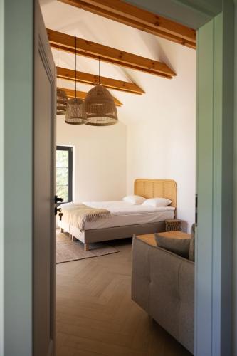a bedroom with a bed and a couch at Zakątek nad Wkrą in Goławice