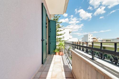 a balcony with green shutters and plants on a building at LuEDa House - Trasfertisti e Turisti in Surbo
