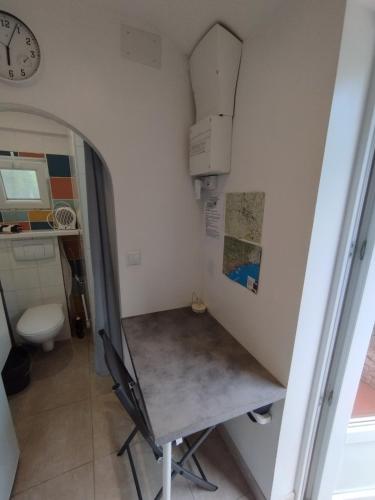une petite pièce avec un bureau et une horloge dans l'établissement studio du soleil rez de jardin avec parking gratuit, à Vence
