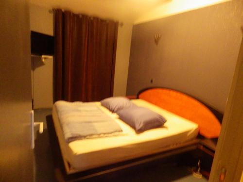 een bed met twee kussens erop in een kamer bij villa climatisée avec grande piscine in Saint-Laurent-de-la-Salanque