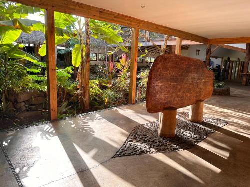 um banco de madeira sentado num pátio em Hotel Hotu Matua em Hanga Roa