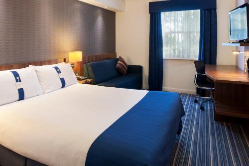 a hotel room with a large bed and a desk at Holiday Inn Express Leeds-East by IHG in Leeds