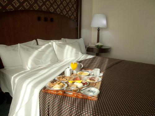 a tray of breakfast foods on a bed at Abasto Hotel in Buenos Aires