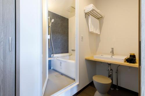 阪井市的住宿－Oruga Resort -Trailer Cottage & Cafe -，带浴缸、盥洗盆和卫生间的浴室