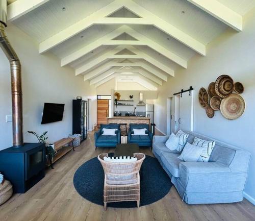 a living room with a blue couch and a table at The Old Oke Riverhouse in Malgas