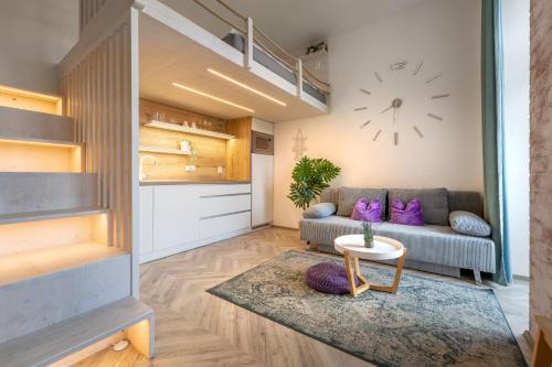 a living room with a couch and a clock on the wall at Internesto Brno Vlhka 9 in Brno