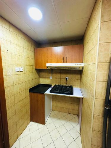 a small kitchen with a sink and a stove at The Welcoming Wing in Ajman 