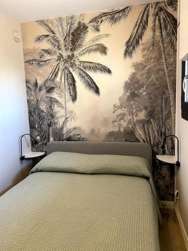 - une chambre avec un lit orné d'une fresque murale de palmiers dans l'établissement Appartement T2 bord de mer, à Hyères