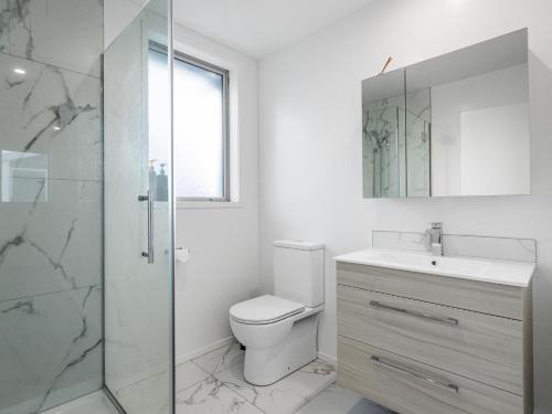 Un baño con inodoro, lavabo y ducha. en Central City Heaven Spa, en Christchurch