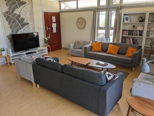a living room with two couches and a tv at Ironcroft Hunter Valley Wine Country in Nulkaba