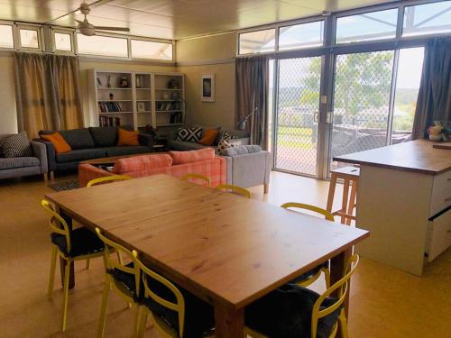 a living room with a wooden table and chairs at Ironcroft Hunter Valley Wine Country in Nulkaba