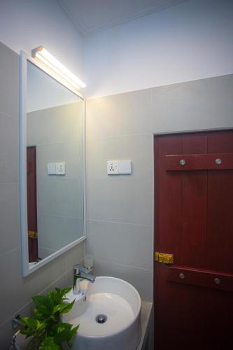 a bathroom with a white sink and a mirror at Villa Nutmeg Grove Galle in Galle