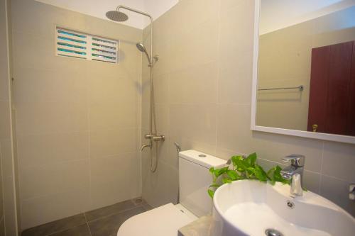a bathroom with a toilet and a sink and a mirror at Villa Nutmeg Grove Galle in Galle