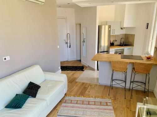 un salon avec un canapé blanc et une cuisine dans l'établissement Superbe appartement en plein centre de Cannes, à Cannes