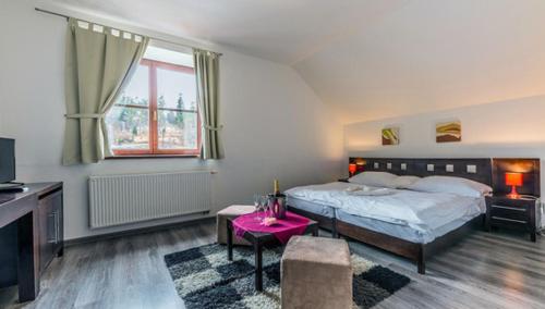 una camera con letto e tavolo rosa di Hotel Tulipan a Tatranská Lomnica