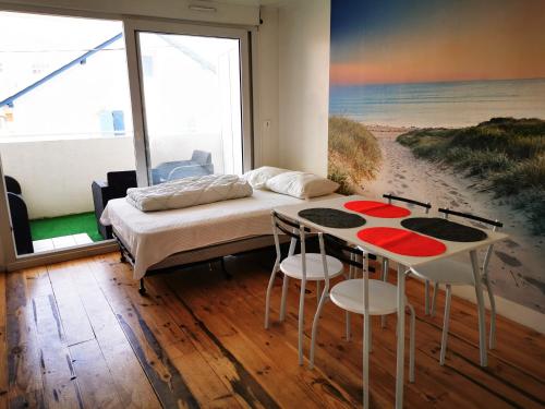 - une chambre avec un lit et une table avec des tabourets dans l'établissement Residence le Sabaou, à Biarritz