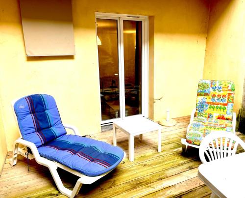 two chairs and a table on a patio at Appartement avec terrasse au coeur d'Aurillac in Aurillac