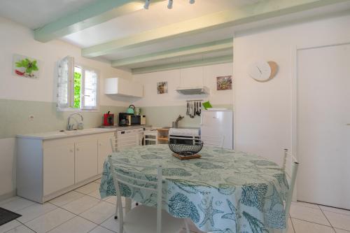 une cuisine avec une table recouverte d'une nappe dans l'établissement L'olivier, à Saint-Just