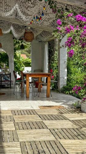 une table et des chaises en bois sur une terrasse fleurie dans l'établissement Maison, Piscine, Jardin & Calme, à Marseille