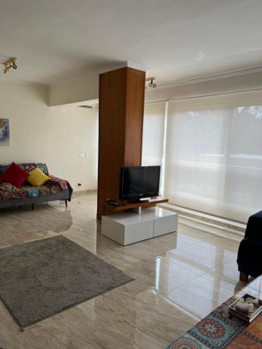 a living room with a flat screen tv on a table at Lovely gorgeous apartment among green Maadi in Cairo