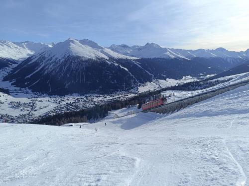 a train is going down a snow covered mountain at Ferienwohnung Parsenn Peaks Panorama in Davos