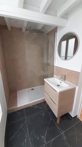 une salle de bain avec un lavabo, une baignoire et un miroir dans l'établissement Appartement T2, Caen centre, à Caen