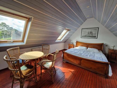 une chambre avec un lit, une table et des chaises dans l'établissement Holiday Home on Pink Granite Coast with Sea View, à Penvénan