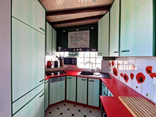 une cuisine avec des armoires vertes et des comptoirs rouges dans l'établissement Holiday Home on Pink Granite Coast with Sea View, à Penvénan
