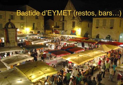 Une foule de gens se tenant autour d'un marché avec des parapluies dans l'établissement CYBÈLE, à Bernac