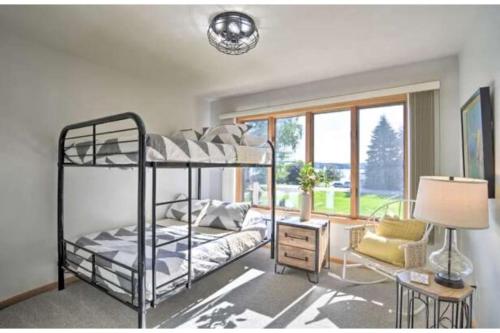 um quarto com um beliche e uma janela em Beautifully Appointed Elk Lake View Home - Steps from the Lake em Williamsburg
