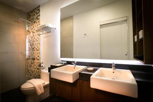 a bathroom with two sinks and a toilet and a mirror at H Boutique Hotel Sri Petaling in Kuala Lumpur