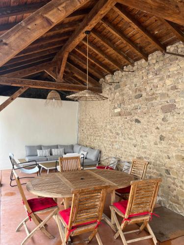 a dining room with a wooden table and chairs at Bulles en Beaujolais Spa & Sauna in Fleurie