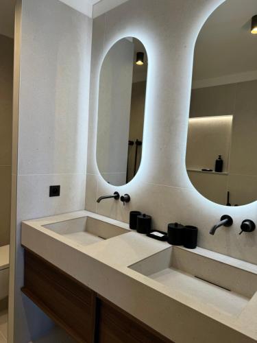 une salle de bain avec un lavabo et un grand miroir dans l'établissement Hyper Centre, Front De Mer, à Ajaccio