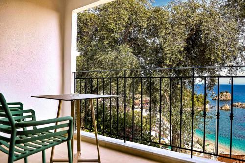 a balcony with a table and chairs and a view of the ocean at Lithitsa Lofts and Suites in Parga